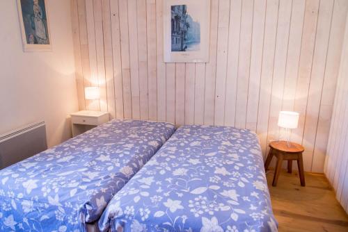 a bedroom with a bed with a blue blanket at Maison pierre de mercoeur in Le Malzieu-Ville