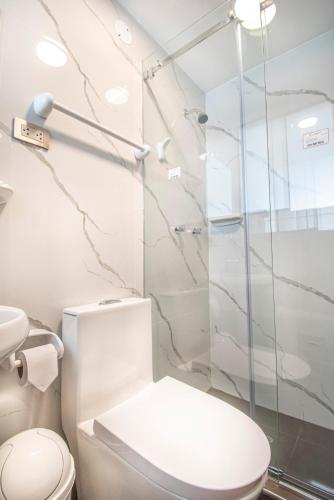 a bathroom with a toilet and a glass shower at Samakuy Home Arequipa in Arequipa