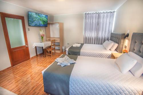 a hotel room with two beds and a tv at Samakuy Home Arequipa in Arequipa