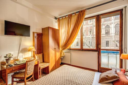 Habitación de hotel con escritorio y ventana en Trastevere Rooms, en Roma