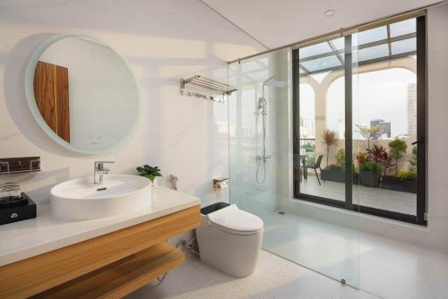 a bathroom with a toilet and a sink and a mirror at BRIO Ventura Apartment in Danang