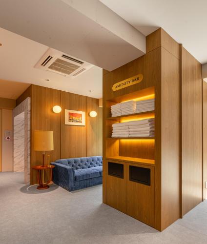 a waiting room with a blue couch and a chair at Hotel EN-YO in Tokyo