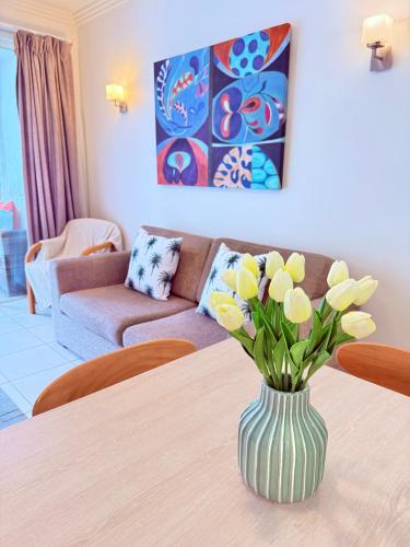 a vase of flowers on a table in a living room at Reefside Escape Silkari Resort in Port Douglas