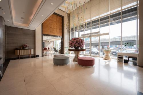 a lobby with tables and chairs and a large window at Weekend Hotel Sari in Jeddah