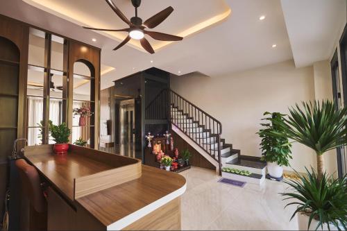 a living room with a ceiling fan and potted plants at La Mejor Homestay in Quang Tri