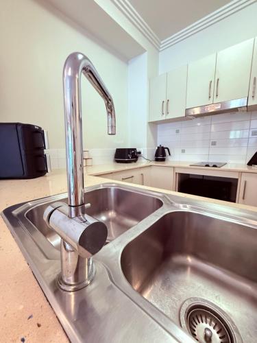 a kitchen sink with a faucet in a kitchen at Reefside Escape Silkari Resort in Port Douglas