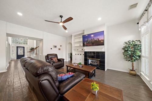 a living room with a leather couch and a fireplace at Houston Lake Retreat Pool Lake Front Spa in Humble