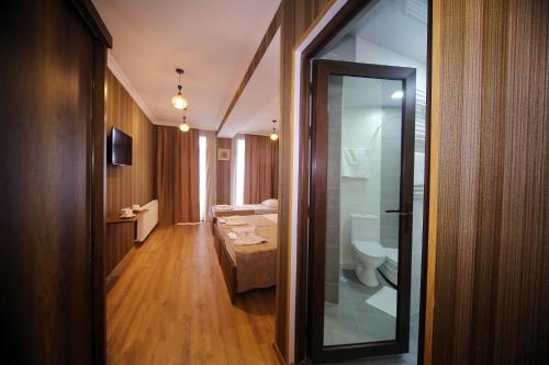 a bathroom with a toilet and a glass doorway at Snow King Hotel in Bakuriani
