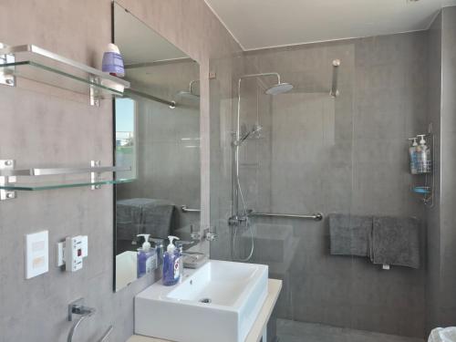 a bathroom with a sink and a shower and a mirror at Scandi Villas Boracay by Simple Realty Management in Boracay