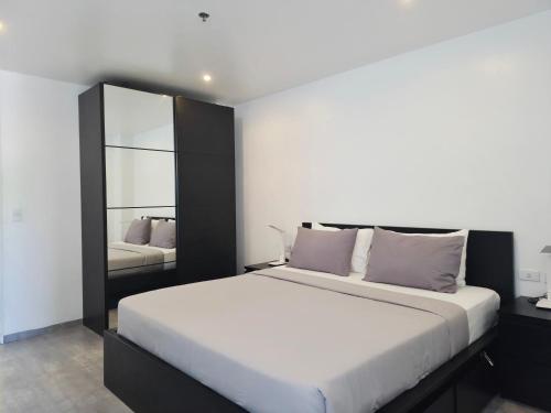 a bedroom with a large bed and a mirror at Scandi Villas Boracay by Simple Realty Management in Boracay