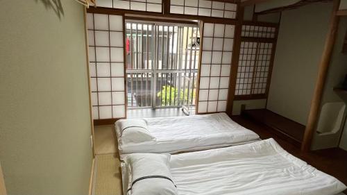 a room with two beds in front of a window at waen in Karahashi Rashomon