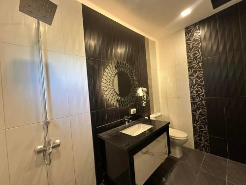a bathroom with a sink and a toilet and a mirror at Cambridge Guest House in Mandaue City