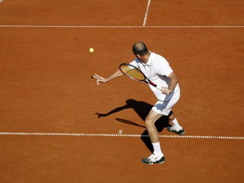 a man hitting a tennis ball with a racket at Hotel Anna in Harrachov