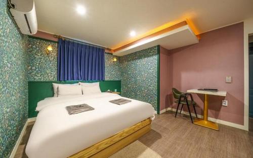 a bedroom with a large bed and a desk at My 24 Motel in Incheon