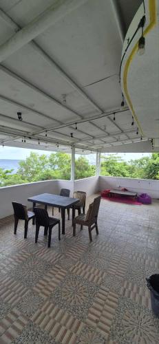 a patio with a table and chairs on a roof at White Beach Villa in Dauis