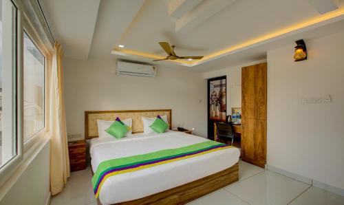 a bedroom with a large bed with colorful sheets at Casa Verde in Cochin