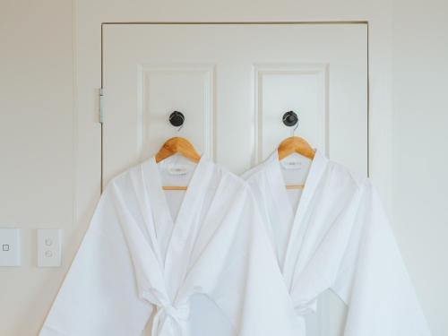 a white robe hanging on hangers in a closet at Commercial Hotel Boonah in Boonah