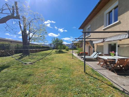 a yard with a fence and a table and chairs at Gîtes de l'AKWABA hébergements T2 et T3 et 1 chambre à la nuitée in Buzet-sur-Baïse