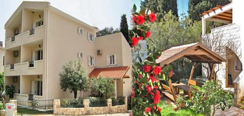 a building with red roses in front of it at Apartments Maris in Petrovac na Moru