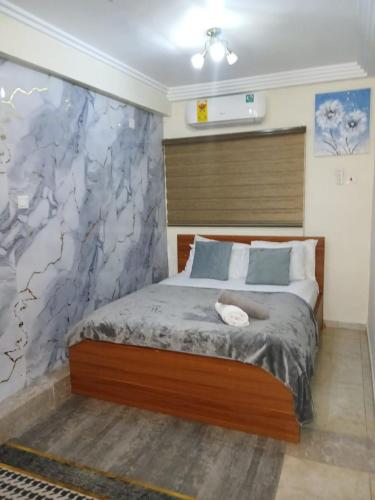 a bedroom with a bed with a marble wall at Natako Apartments in Apenkwa