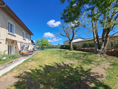 a grassy yard with trees and a building at Gîtes de l'AKWABA hébergements T2 et T3 et 1 chambre à la nuitée in Buzet-sur-Baïse