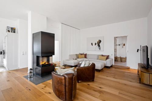 a living room with a couch and a fireplace at ACKERBÜRGERHAUS - Historische Ferienwohnung mit 4 Schlafzimmern, Kamin, Sauna, Balkon-Terasse, Altstadt und See 5 Min zu Fuß, Moderne Küche, Parkplatz, WLAN in Eutin