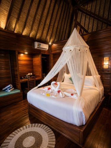 a bedroom with a bed with nets on it at Alinn Villas in Nusa Lembongan
