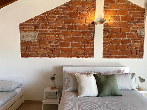 a bedroom with a brick wall and a bed at B&B Il Rosmarino in Galliate