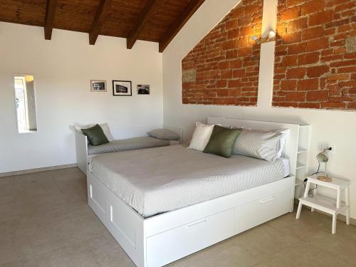 a bed in a room with a brick wall at B&B Il Rosmarino in Galliate