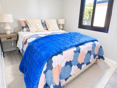 a bedroom with a bed with a blue comforter at Alpaca Haven Farm in Rotorua