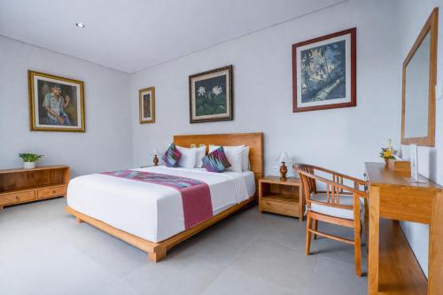 a bedroom with a bed and a desk and a desk at Villa Bawa in Ubud