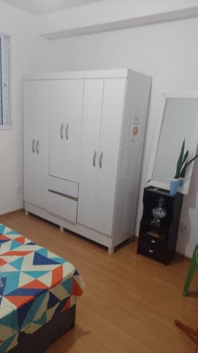 a bedroom with white cabinets and a bed at Apartamento Compacto Localização Privilegiada in Uberaba