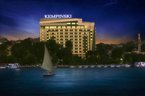 a sail boat in the water in front of a building at Kempinski Nile Hotel, Cairo in Cairo