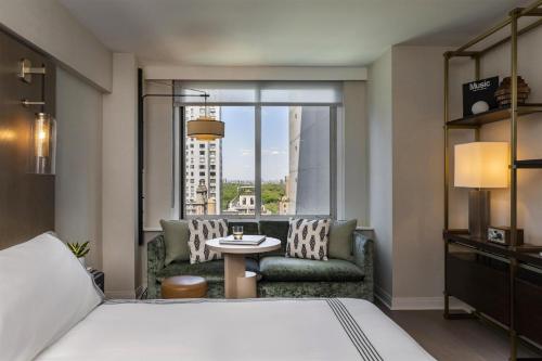 a hotel room with a bed and a table and a window at Thompson Central Park New York, by Hyatt in New York