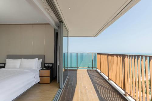 a bedroom with a bed and a balcony at Wyndham Soleil Danang - Free Schedule Airport Shuttle in Danang