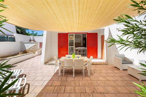 a patio with a table and chairs in a house at 066 Le Fontanelle by SalentoInVacanzaCOM in Fontanelle