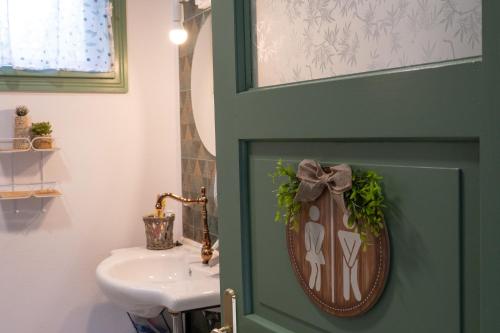 a green door in a bathroom with a sink at Mese Szálló in Lăzarea