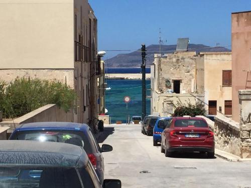 a group of cars parked on a street next to the ocean at Favignana Vacanze in Favignana