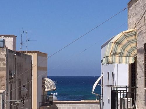 a view of the ocean from between two buildings at Favignana Vacanze in Favignana