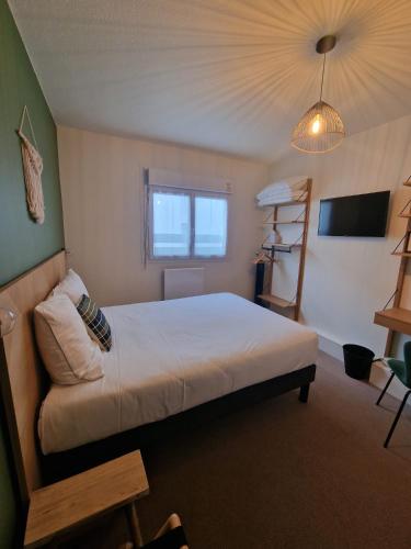 a bedroom with a large bed and a window at Brit Hotel Kara Sainte Anne d'Auray in Sainte Anne d'Auray