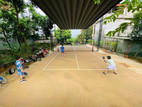 a group of people playing tennis on a tennis court at HomeStay Pickle ball in Ðồng Vo
