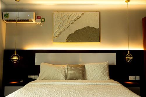 a bedroom with a bed and a picture on the wall at La Grande Hotel in Kampala