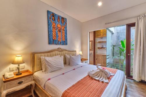 a bedroom with a large bed and a window at Miko Villas Ubud in Ubud