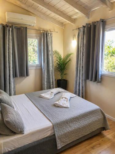 a bedroom with a bed with two towels on it at Logaki house in Vlachopoulátika