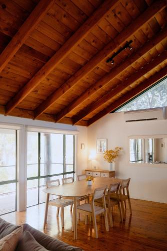 a dining room with a wooden table and chairs at Norfolk House in Dunsborough