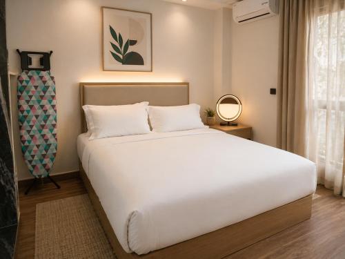 a bedroom with a large white bed in a room at Hotel Albatros Wallis in Alele