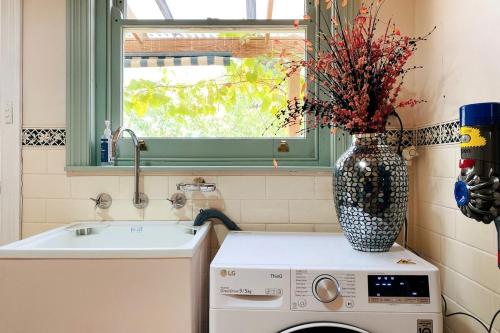 a kitchen with a vase on top of a washing machine at Hidden Getaway in the City in Mount Gambier