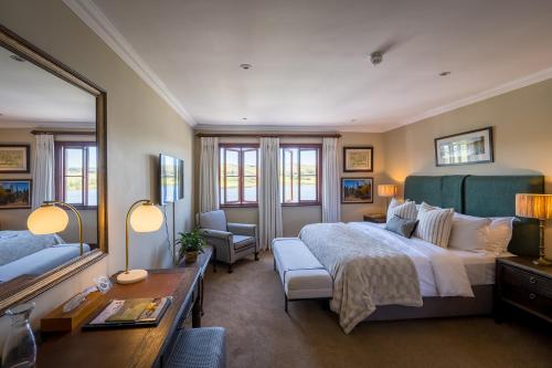 a large bedroom with a large bed and a mirror at Gowrie Farm Golf Lodge in Nottingham Road