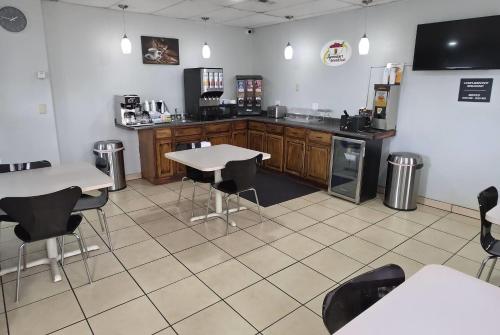 a room with a kitchen with tables and chairs at Super 8 by Wyndham Yankton in Yankton