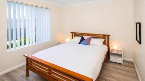 a bedroom with a bed and a large window at Studio 66 Busselton in Busselton